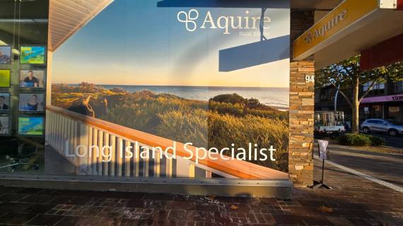 Window vinyl wrap of Aquire Real Estate.